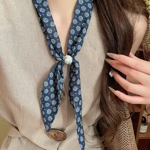 Primer plano de un pañuelo retro de algodón y lino con flores y un anillo de mármol.