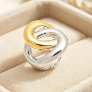 Gros plan d'une bague géométrique torsadée bicolore en acier inoxydable poli