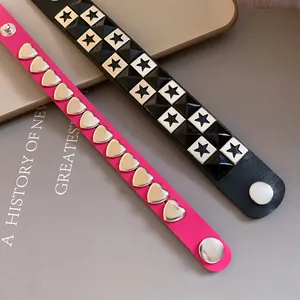 Detail shot of punk leather bracelets with metallic heart and star shaped studs