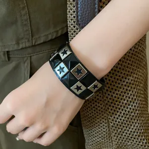Close-up of black leather cuff bracelet with metal star and pyramid stud details