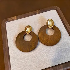 Elegante runde Holzohrringe im Retro-Stil mit poliertem goldenem ovalem Stecker-Design