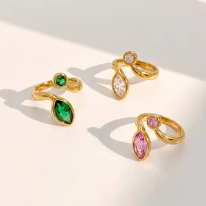 Close-up of gold stainless steel rings with green, pink, and clear marquise zircons.