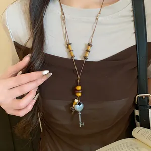 Detail der Vintage-Halskette im Ethno-Stil mit Herzschlüssel-Anhänger und Holzperlen