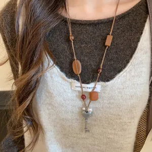 Detailaufnahme einer Boho-Lederhalskette mit Holzperlen und Herz-Schlüssel-Anhänger