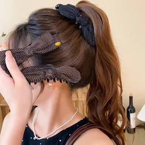 Fermagli per capelli a fiocco a pois indossati per un'acconciatura retrò