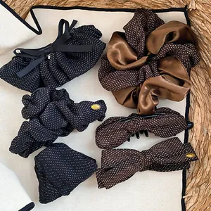 Dettaglio di fermagli per capelli con fiocco a pois vintage e elastici in raso