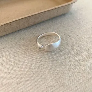 Detail shot of a minimalist matte silver open ring featuring a subtle zircon accent.