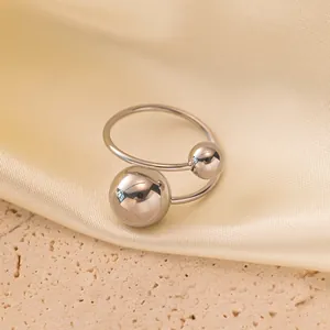 Macro dettaglio di un anello aperto in acciaio inossidabile argento con due sfere lucide