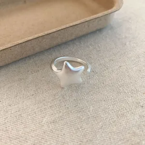 Detailed macro view of a minimalist matte silver star ring showing fine S925 hallmark texture