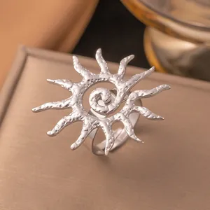 Primo piano di un anello aperto in acciaio inossidabile argentato a forma di sole.