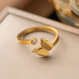 Dettaglio dell'anello a farfalla dorato con un cristallo scintillante per donna
