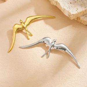 Detailed macro shot of elegant gold and silver swallow-shaped stainless steel brooches