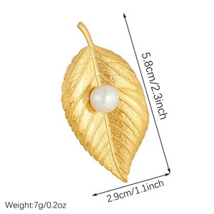Close-up detail of a gold plated stainless steel leaf brooch with pearl measurements.