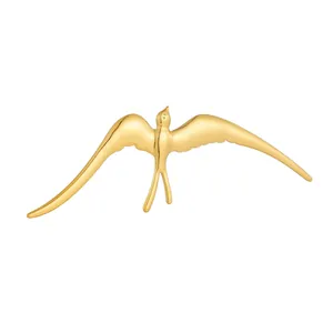 Detailed view of gold-plated stainless steel swallow bird brooch with smooth finish