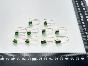 Vista detallada de pendientes de gancho de acero chapado en oro 18K con circonitas verdes