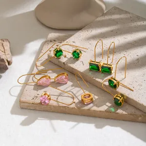 Primer plano de pendientes de acero inoxidable chapados en oro de 18K con circonitas.