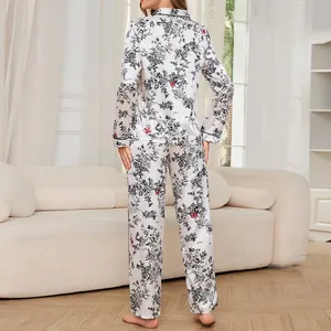 Back view of woman in white satin pajama set with black floral pattern for homewear