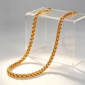 Détail macro d'un collier chaîne de blé en acier inoxydable plaqué or 14 carats