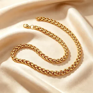 Vue détaillée d'un collier en chaîne à mailles dorées texturées sur un tissu en soie