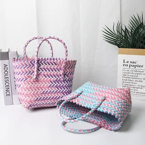 Primer plano de cestas tejidas de colores hechas a mano con motivos rosas, azules y morados