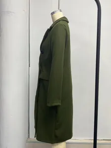 Side view of dark green double-breasted long-sleeve wool coat with pockets on mannequin display