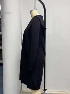 Détail d'un cardigan en maille à capuche noir ample présenté sur un mannequin.