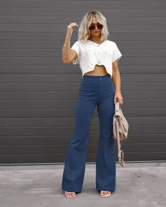 High-waisted blue corduroy flared pants with button closure in a stylish outdoor setting.