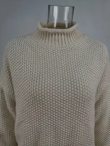 Close-up of a high neck chunky knit sweater showing detailed cream yarn texture