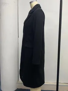 Side view detail of a classic black double-breasted long wool coat for elegant women