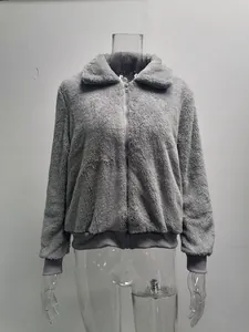 Vue détaillée de la texture polaire teddy grise douce d'une veste d'hiver zippée pour femme.