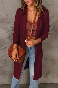 Détail d'un long gilet en maille bordeaux pour femme avec poches au style automnal.