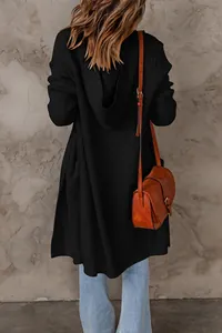 Vue arrière détaillée d'un long gilet en maille noire avec une capuche élégante