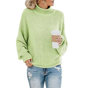 Detailed view of women's oversized chunky knit light green turtleneck sweater texture