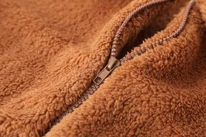 Vue macro d'une veste en polaire teddy marron douce avec détails de fermeture éclair