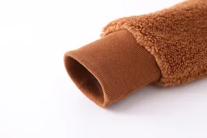 Détail macro du poignet côtelé sur une veste chaude en polaire teddy marron pour femme