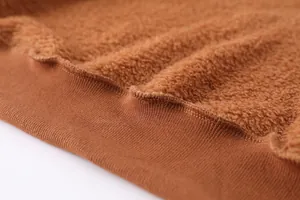 Gros plan sur le tissu polaire teddy marron chaud avec bord-côte à la base