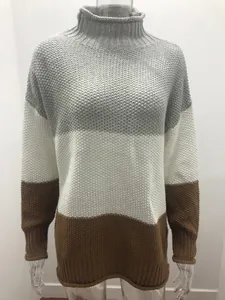 Detail of chunky knit turtleneck sweater with grey, white, and brown color-blocking
