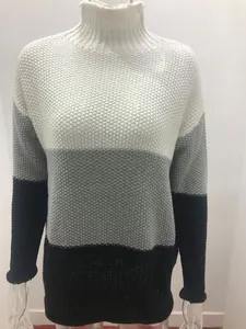 Detailed view of women's color-block turtleneck sweater with chunky knit texture.