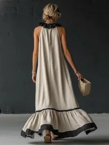 Vista posteriore di un elegante abito lungo beige con balze nere sull'orlo e collo