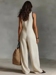 Back view of a woman in an elegant linen blend sleeveless jumpsuit with neutral tones