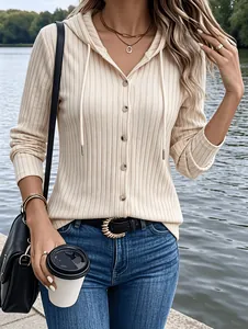 Detailed shot of women's cream ribbed knit hooded cardigan featuring brown buttons and drawstrings