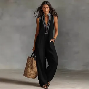 Close-up detail of a black sleeveless linen jumpsuit with an embroidered stand collar