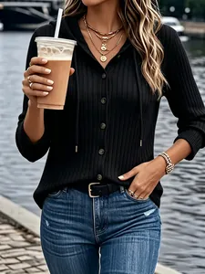 Detailed view of women's black ribbed long sleeve buttoned hoodie in a lifestyle setting