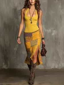 Full length view of a fashion model wearing a yellow halter top and patchwork slit midi skirt