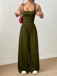 Stilvoller olivgrüner Jumpsuit mit weitem Bein und schmalen Trägern am Modell.
