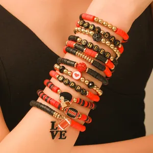 Detalle de pulseras de arcilla con temática de fútbol y dijes de 'CHEER' y 'HAPPY'