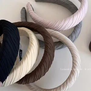 Detailed view of pleated padded sponge headbands in a variety of elegant neutral colors