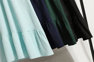 Detail des Rüschensaums an langärmeligen Chiffonkleidern in eleganten Farben.