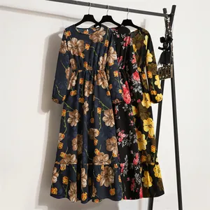 Drei elegante langärmelige Maxikleider aus Chiffon mit Blumenmuster an einem Kleiderständer