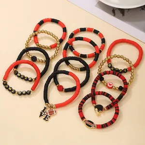 Detalle de pulseras de cuentas de arcilla polimérica de fútbol con dijes rojos y negros.